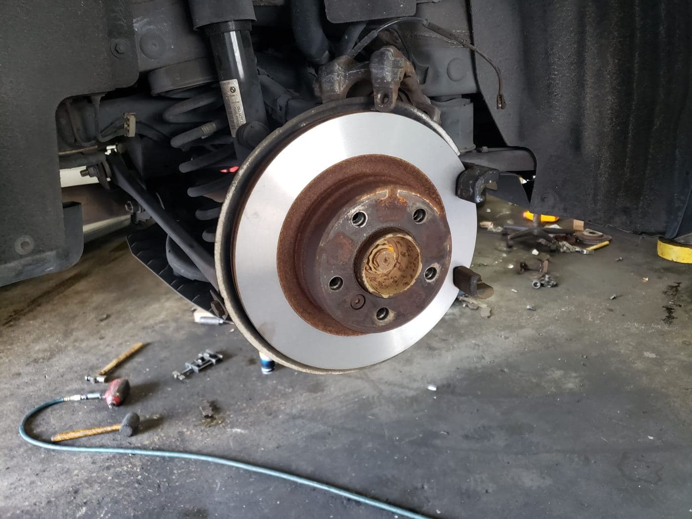 New brake rotor installed on a car inside the shop